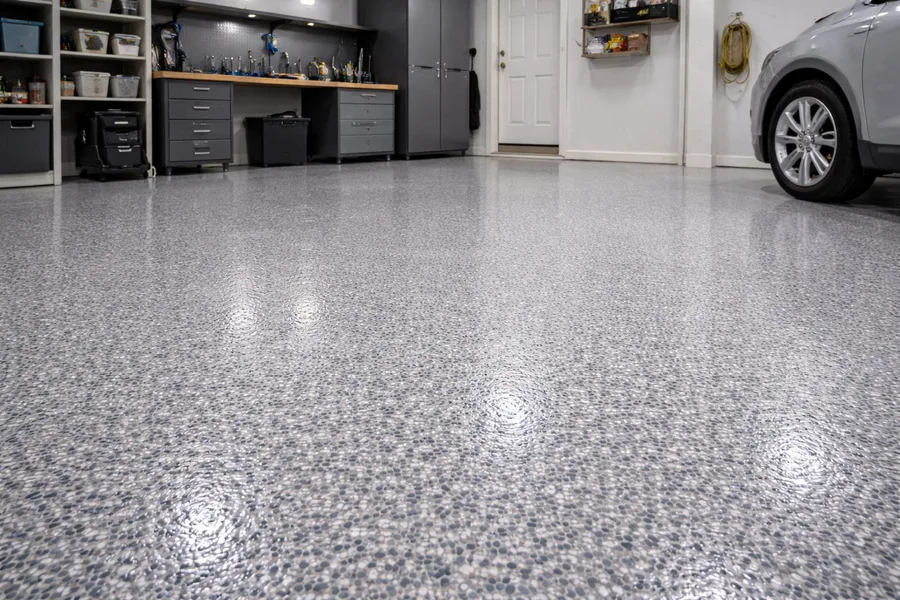 Topcoat refresh result — refreshed decorative flake garage floor with deep gloss finish and parked vehicle