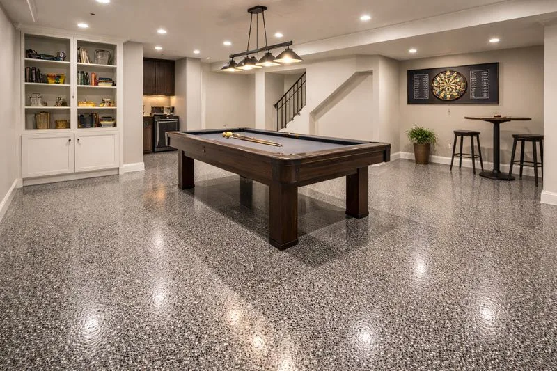 Finished basement recreation room with charcoal decorative flake epoxy floor, pool table, and dartboard